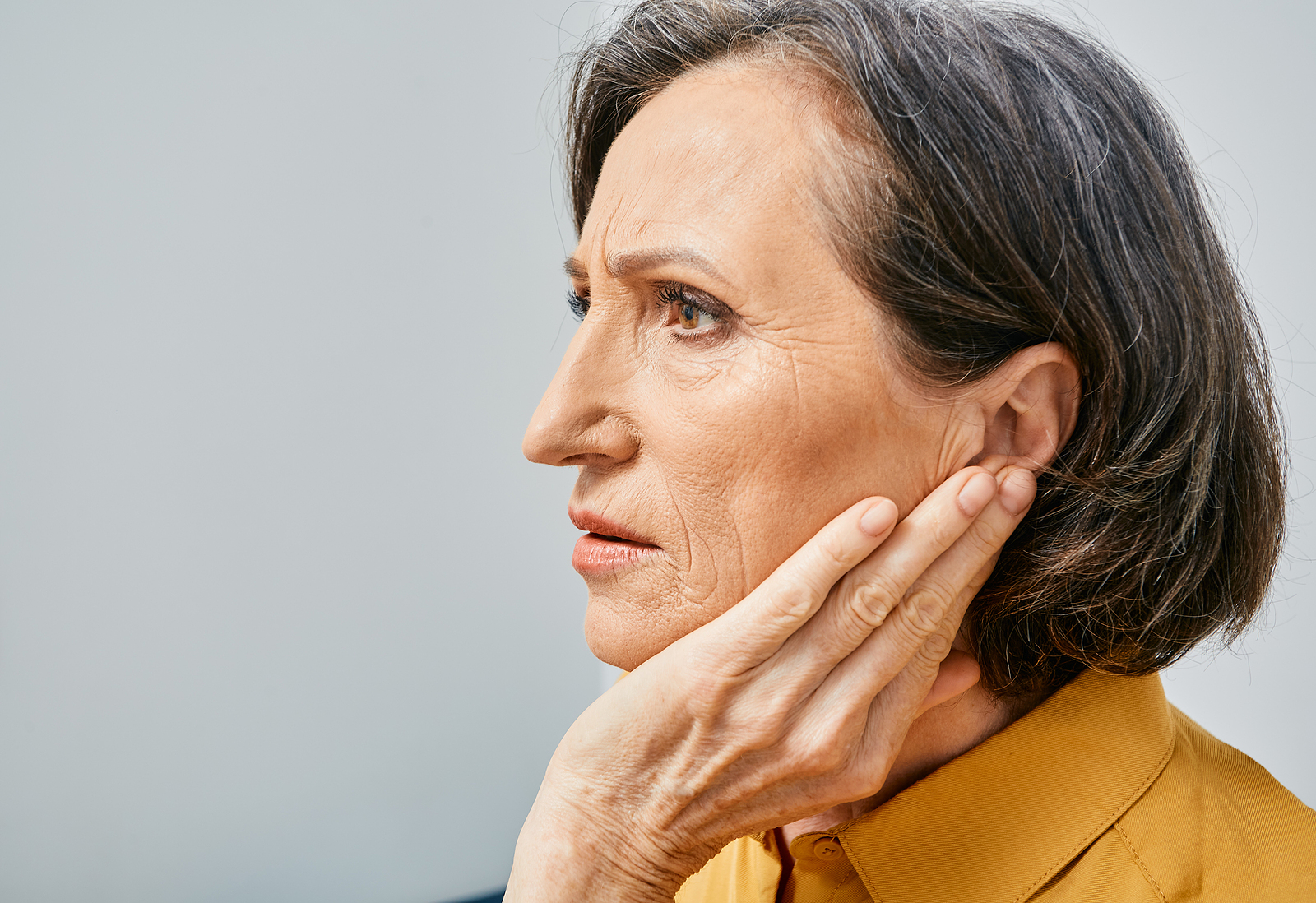 Hearing Loss. Mature Woman With Hearing Problems Touching Ear Wi