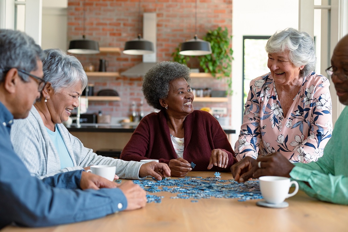 Group of diverse senior male and female friends doing puzzles at